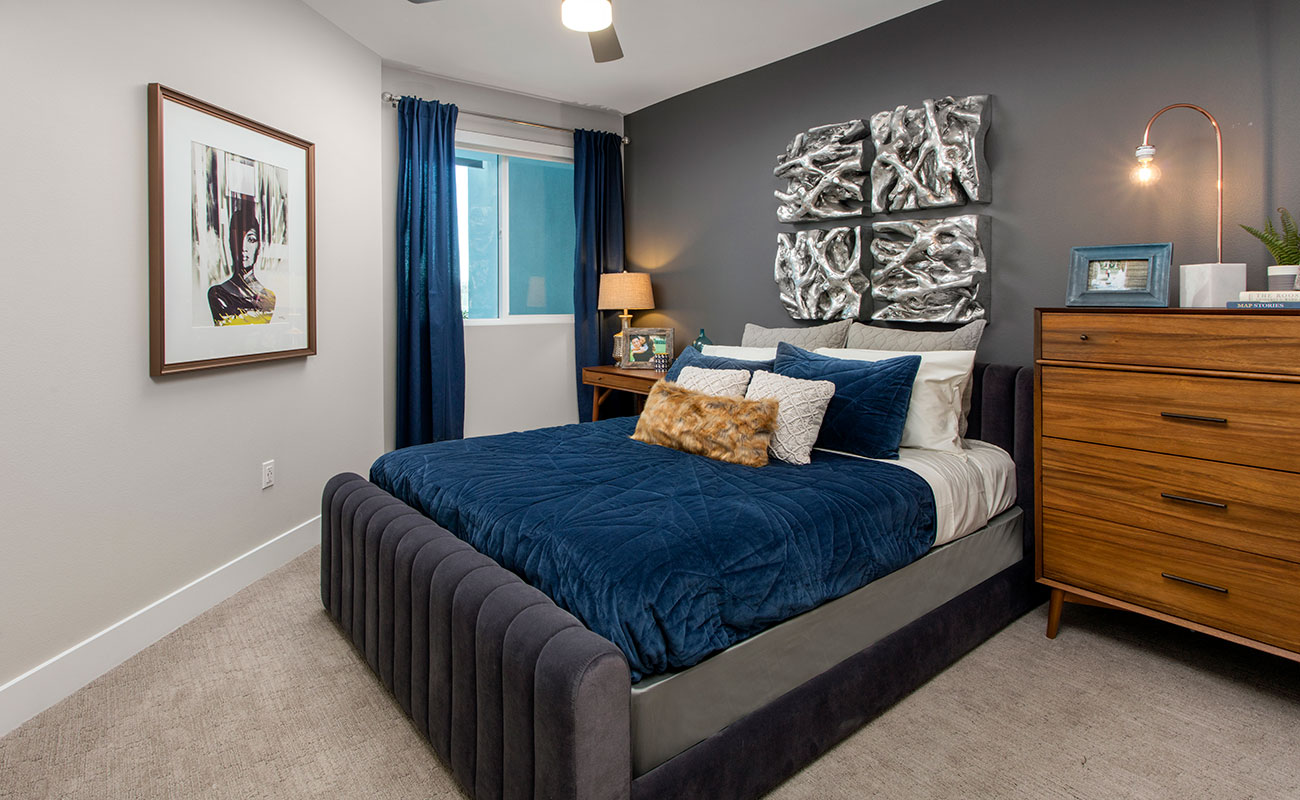 Apartments in Irvine for Rent-The Royce Bedroom with Cozy Plush Carpeting, Ceiling Fan, and Modern Accent Wall